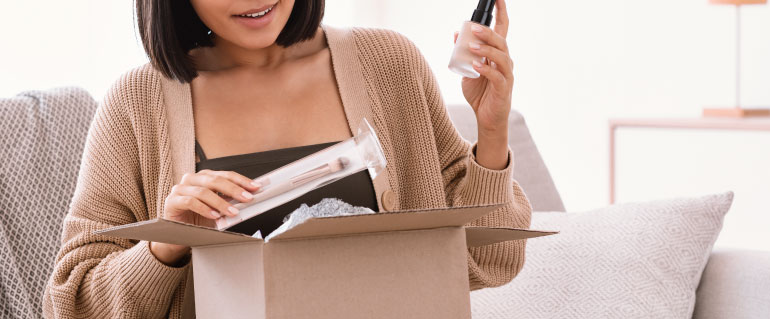 Woman taking cosmetics out of a box